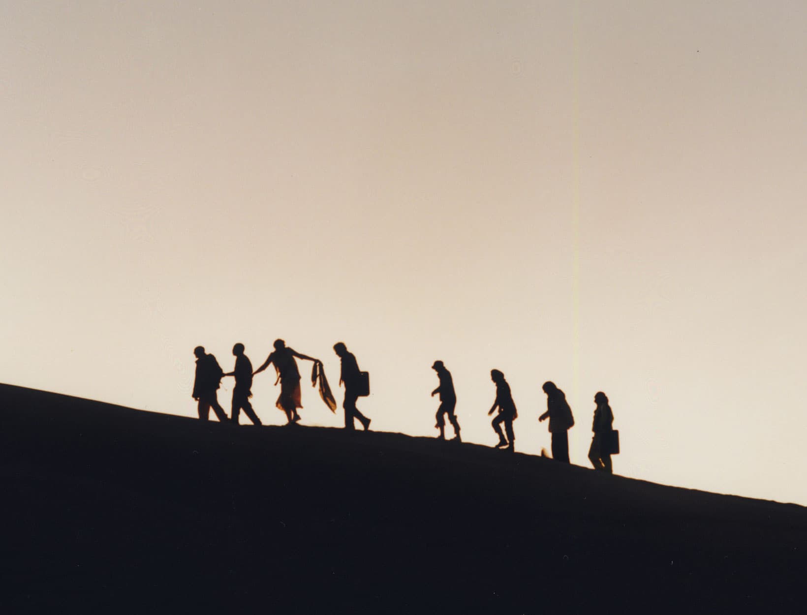 Grupo de personas caminando juntas al atardecer