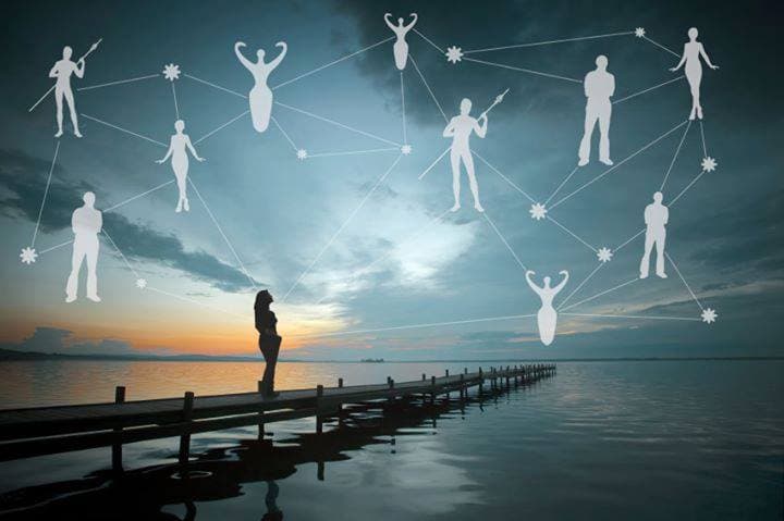 Persona frente al mar al atardecer, con figuras unidas por líneas como una constelación